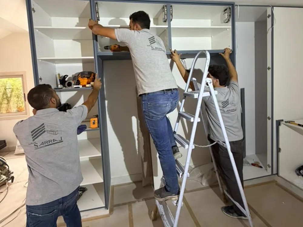 Three Sarraj fitters installing a built-in wardrobe